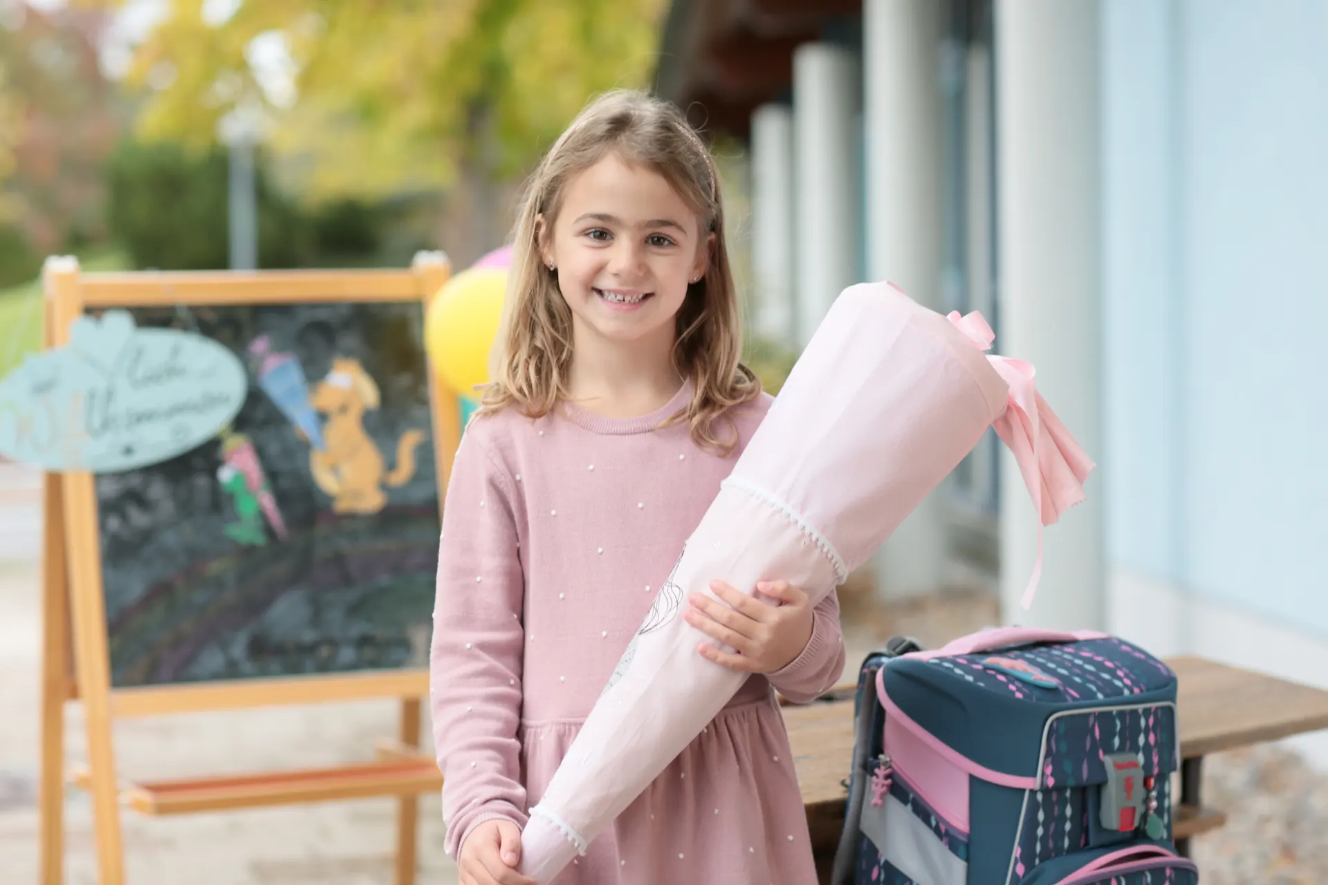 Schulkind mit Schultüte und Ranzen am ersten Schultag